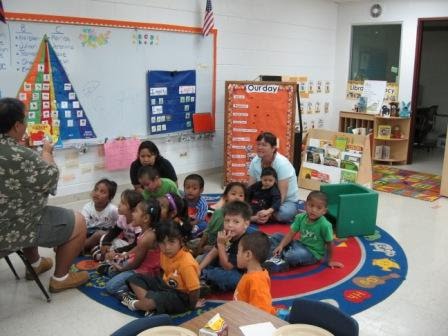 Parents sitting together with their child in a classroom